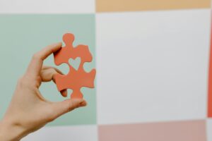 How to choose charity for Will showing hand holding puzzle piece with heart representing thoughtful charity selection and charitable legacy planning